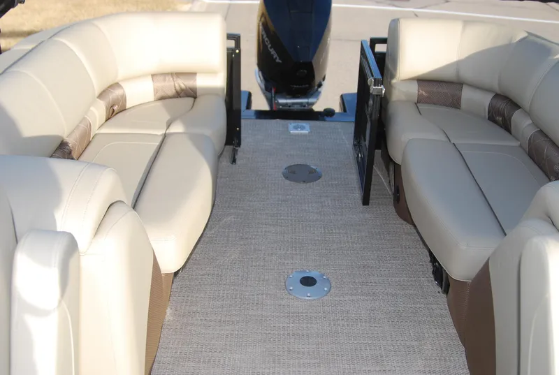 Slide: The Image of 2024 Regency 230 LE3 boat interior with beige seating and carpeted floor. - 6