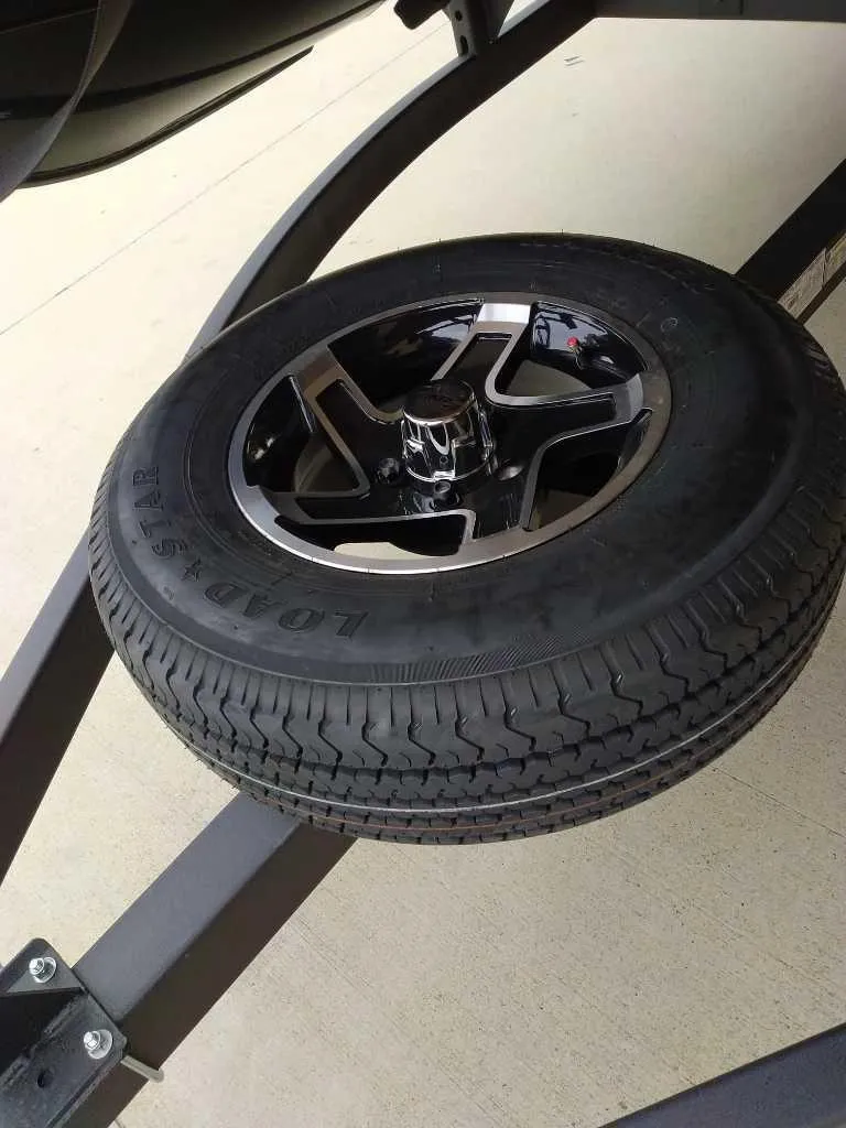 Slide: The Image of 2024 Ranger Reata 200F trailer tire and wheel on pavement. - 11