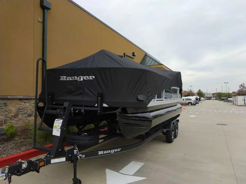 Slide: The Image of 2024 Ranger Reata 200F boat on trailer with cover in parking lot. - 12