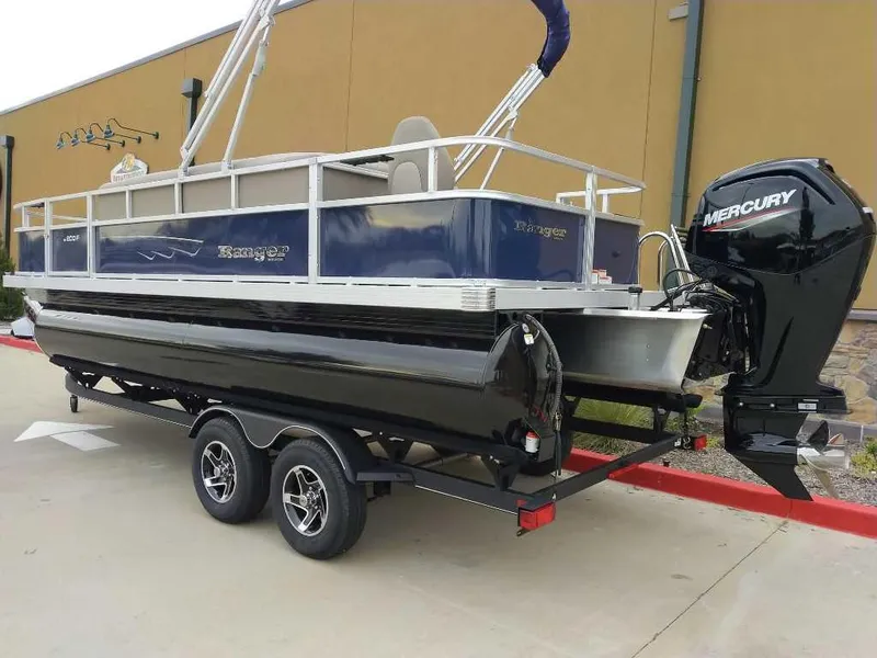 Slide: The Image of 2024 Ranger Reata 200F pontoon boat on trailer with Mercury outboard motor. - 2