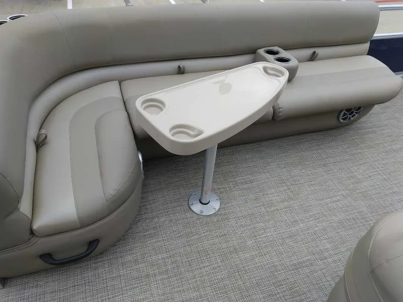 Slide: The Image of 2024 Ranger Reata 200F boat interior with beige seating and table. - 7