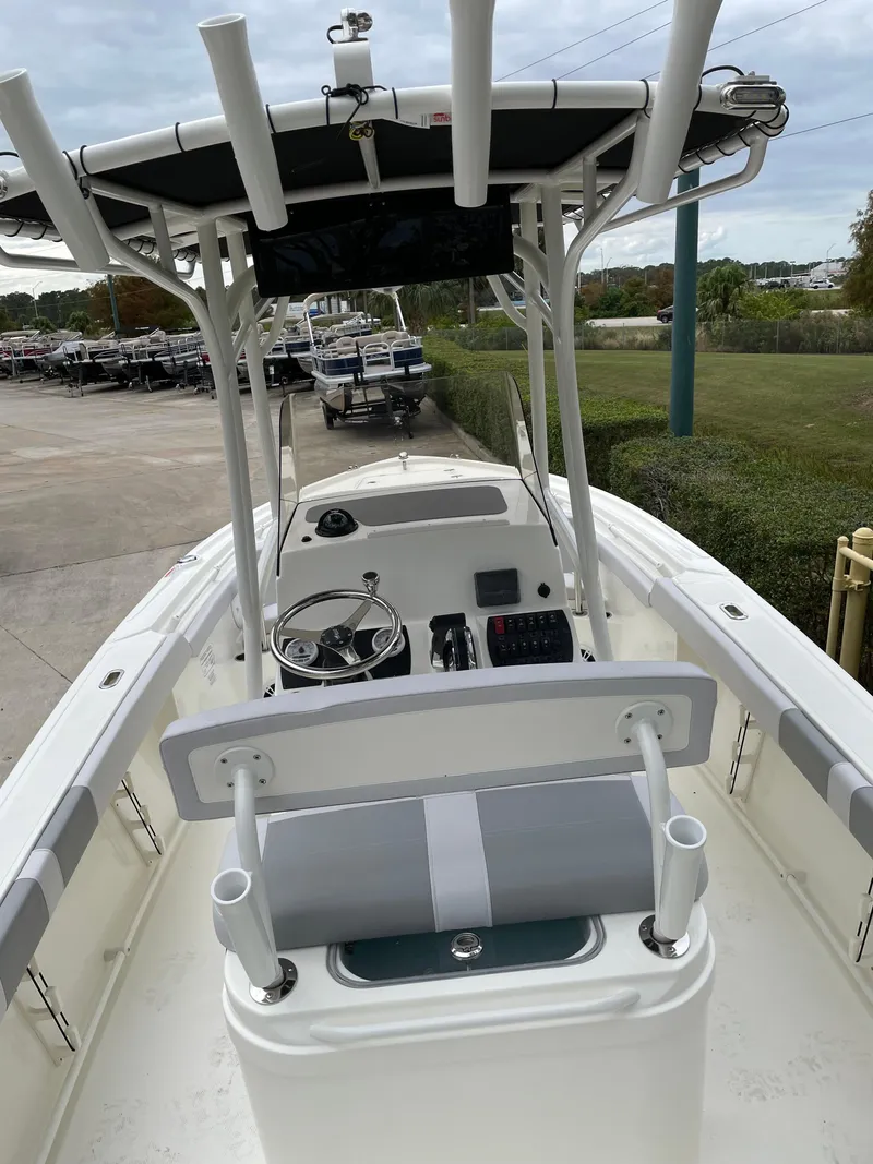 Slide: The Image of 2024 Mako 214 CC boat with center console and T-top in a marina setting. - 4