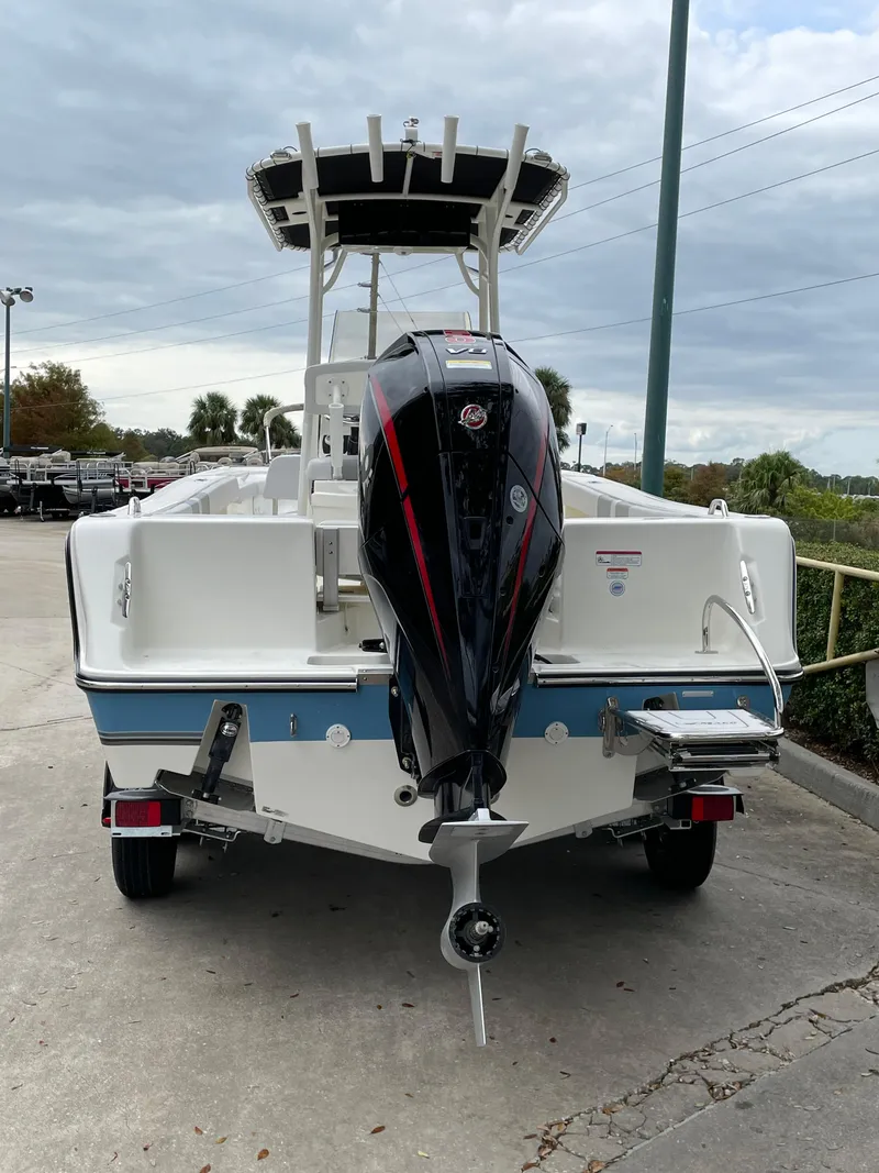 Slide: The Image of 2024 Mako 214 CC boat with outboard motor, parked on concrete. - 6