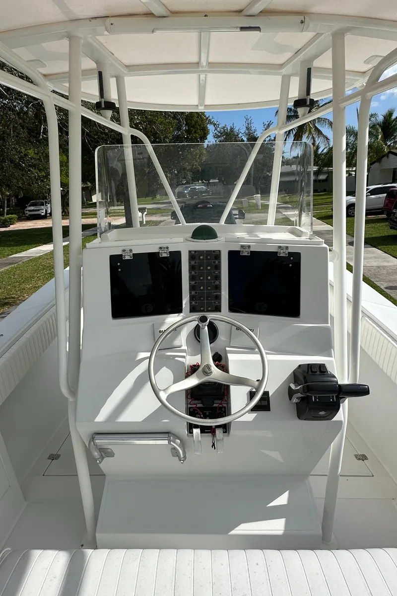 Slide: The Image of 2002 Jupiter 27 Open Fisherman boat console with steering wheel and navigation screens. - 15