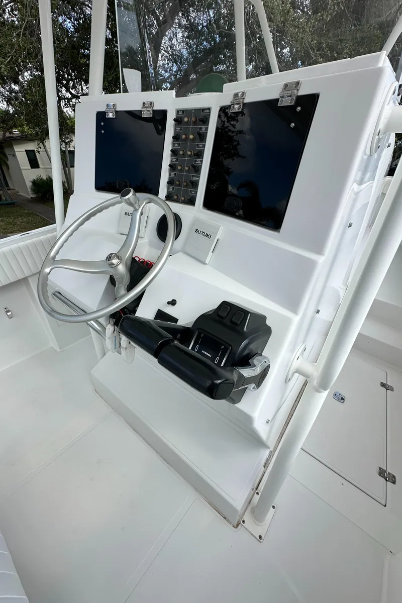 Slide: The Image of 2002 Jupiter 27 Open Fisherman boat console with steering wheel and controls. - 21