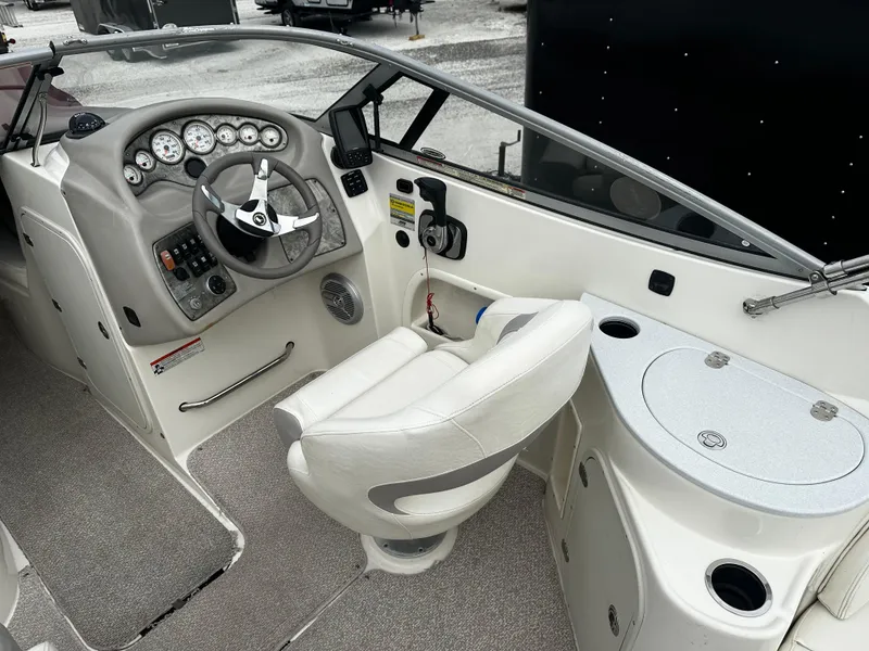 Slide: The Image of 2011 Stingray 250 LR boat cockpit with steering wheel, gauges, and captain's chair. - 18