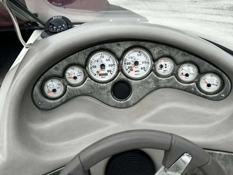 Slide: The Image of Dashboard of a 2011 Stingray 250 LR boat with gauges and steering wheel. - 21