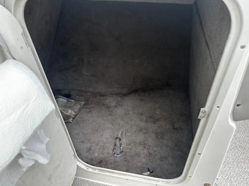 Slide: The Image of 2011 Stingray 250 LR boat storage compartment with carpeted interior. - 26