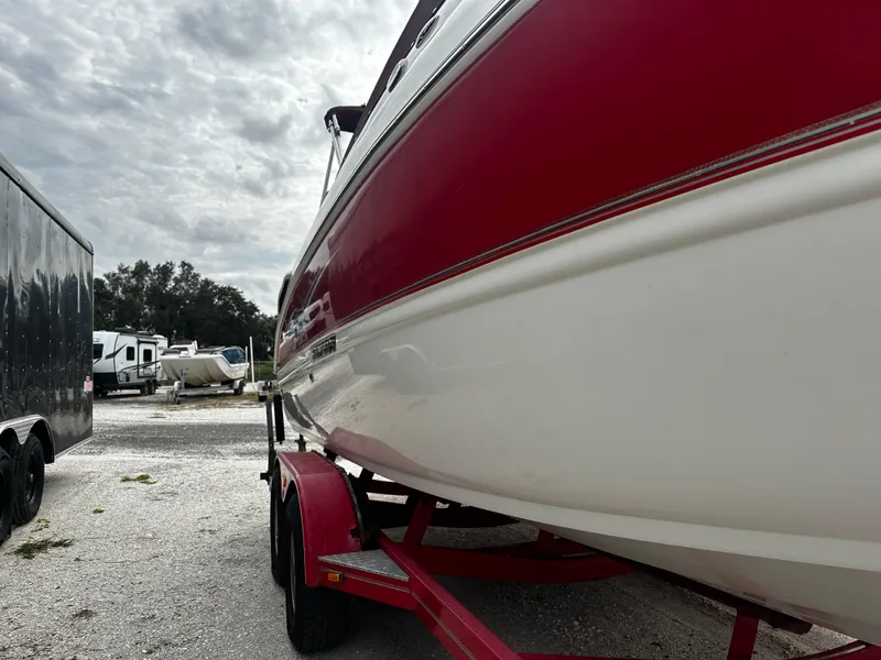 Slide: The Image of 2011 Stingray 250 LR boat on a red trailer in a parking lot. - 3