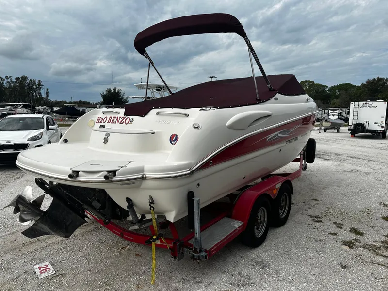 Slide: The Image of 2011 Stingray 250 LR boat on a trailer with a maroon canopy. - 4