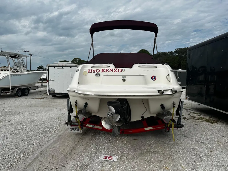Slide: The Image of 2011 Stingray 250 LR boat with maroon canopy in a parking lot. - 7