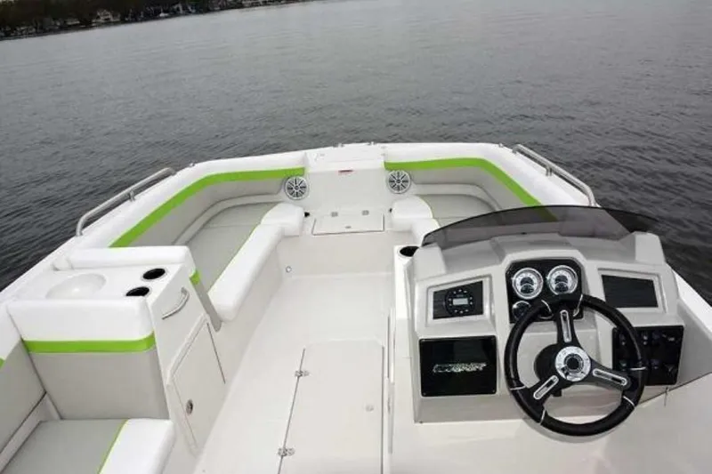 Slide: The Image of 2023 Starcraft SVX 171 OB boat interior with modern dashboard and seating on calm water. - 6
