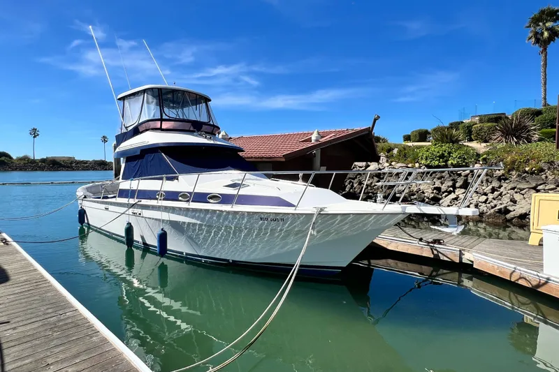 The Image of 1990 Mediterranean 38 Sport Fisher docked in a serene marina setting. - 0