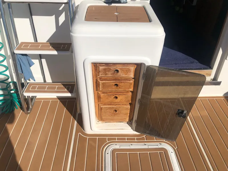 Slide: The Image of 1990 Mediterranean 38 Sport Fisher boat interior with wooden drawers and open cabinet. - 10
