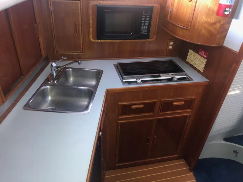 Slide: The Image of 1990 Mediterranean 38 Sport Fisher kitchen with sink, stove, and microwave. - 13