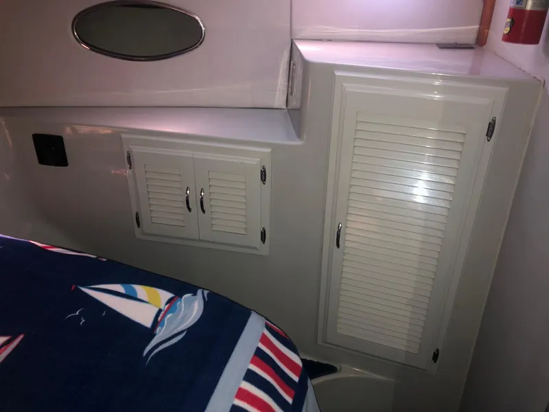 Slide: The Image of Interior of 1990 Mediterranean 38 Sport Fisher with nautical-themed bedding and storage cabinets. - 15