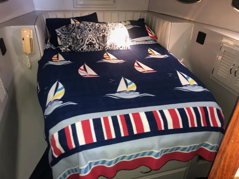 Slide: The Image of Cozy cabin interior of 1990 Mediterranean 38 Sport Fisher with nautical-themed bedding. - 16