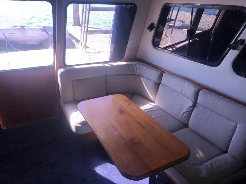 Slide: The Image of Interior of 1990 Mediterranean 38 Sport Fisher with cozy seating and wooden table. - 4