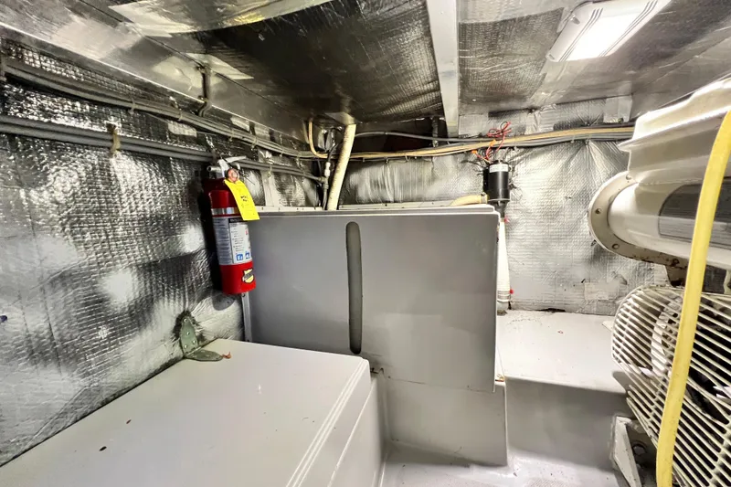 Slide: The Image of Engine room of 1990 Mediterranean 38 Sport Fisher with fire extinguisher and equipment. - 57