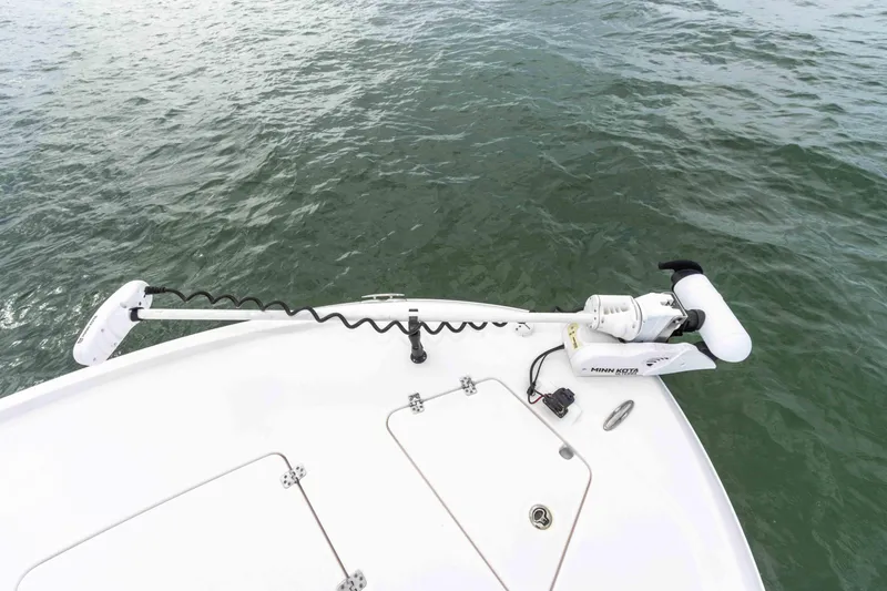 Slide: The Image of 2022 Caymas 281HB Center Console boat bow with trolling motor on water. - 19