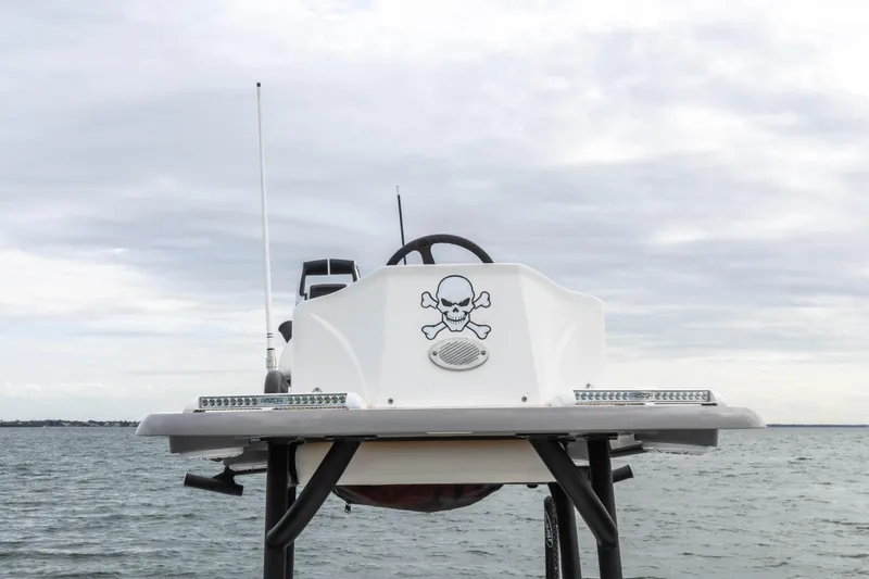 Slide: The Image of 2022 Caymas 281HB Center Console boat with skull and crossbones decal on the water. - 21