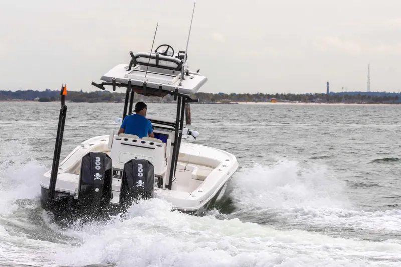 Slide: The Image of 2022 Caymas 281HB Center Console boat cruising on water with dual engines. - 25