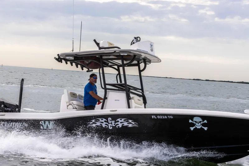 Slide: The Image of 2022 Caymas 281HB Center Console boat cruising on the water with a person at the helm. - 30
