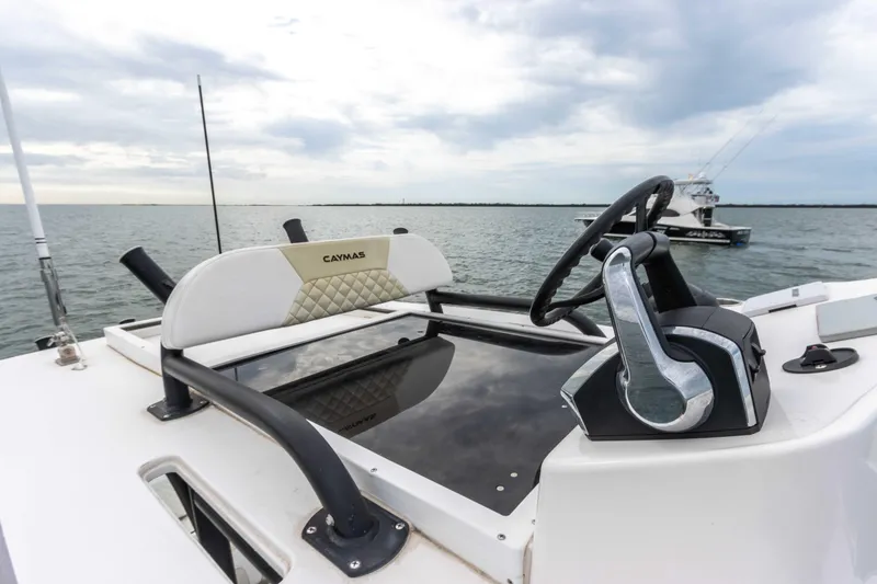 Slide: The Image of 2022 Caymas 281HB Center Console boat helm with steering wheel and throttle controls. - 34