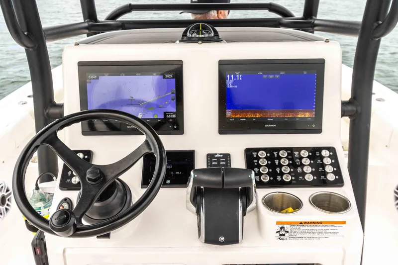 Slide: The Image of 2022 Caymas 281HB Center Console boat dashboard with dual navigation screens and steering wheel. - 40