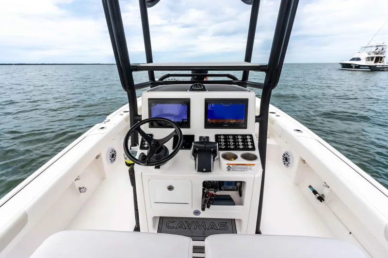 Slide: The Image of 2022 Caymas 281HB Center Console boat dashboard with dual screens on open water. - 43