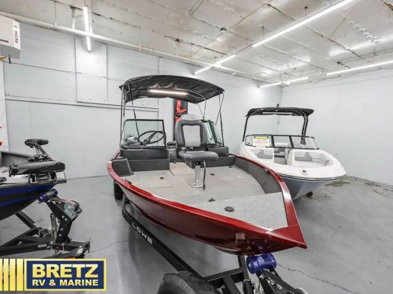 Slide: The Image of 2024 Fishing Machine 1775 WT boat displayed in showroom with canopy and seating. - 1