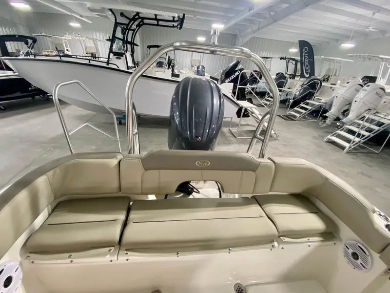 Slide: The Image of 2024 Key West 203 FS boat interior with seating and outboard motor in showroom. - 5