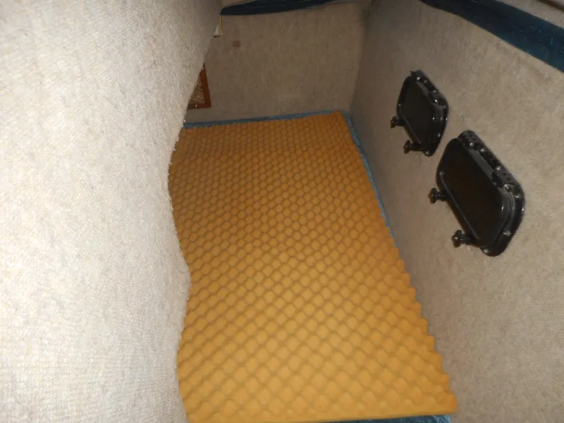 Slide: The Image of Interior cabin of a 1984 Beachcraft Cabin Cruiser with foam mattress and porthole windows. - 13