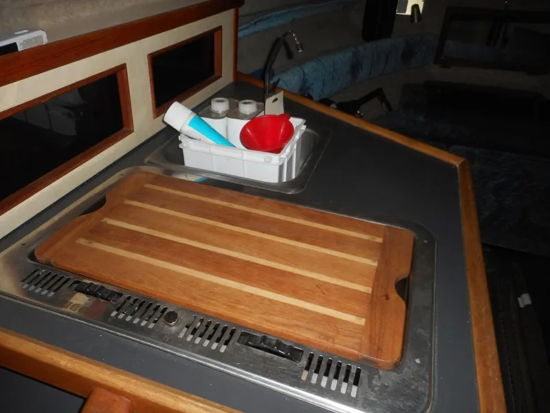 Slide: The Image of 1984 Beachcraft Cabin Cruiser kitchen area with cutting board and sink. - 14