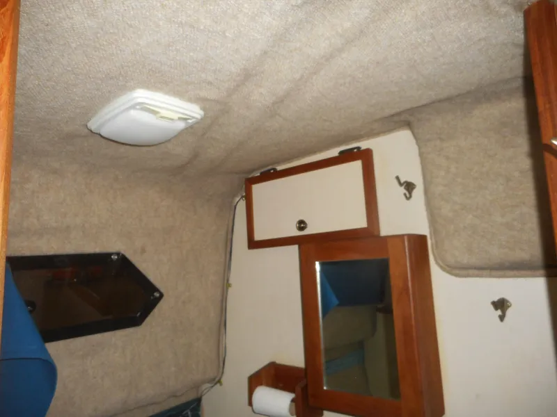 Slide: The Image of Interior of a 1984 Beachcraft Cabin Cruiser with wooden cabinets and a small mirror. - 18