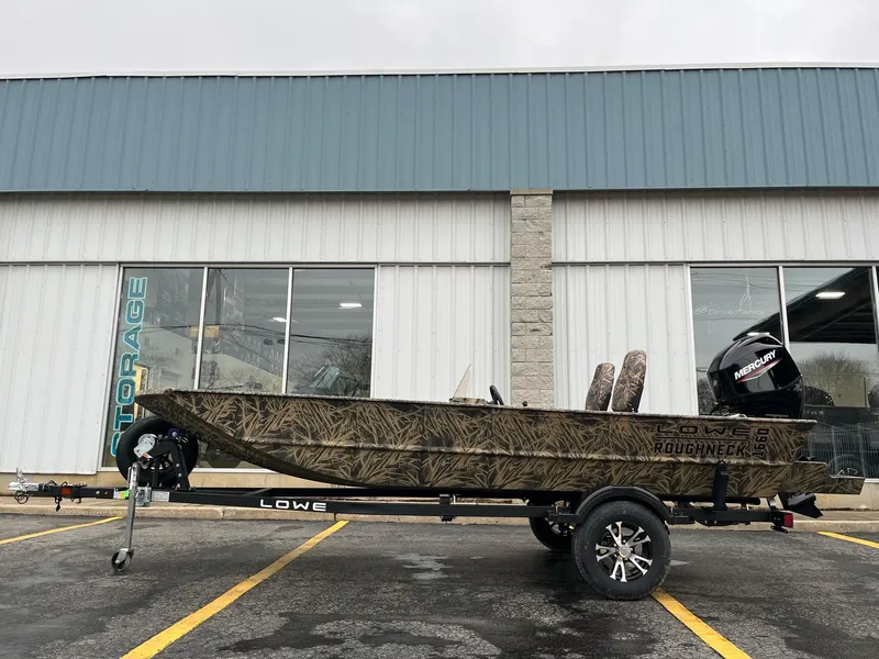 The Image of 2024 Lowe Roughneck RX1660 SC camo boat on trailer in parking lot. - 0