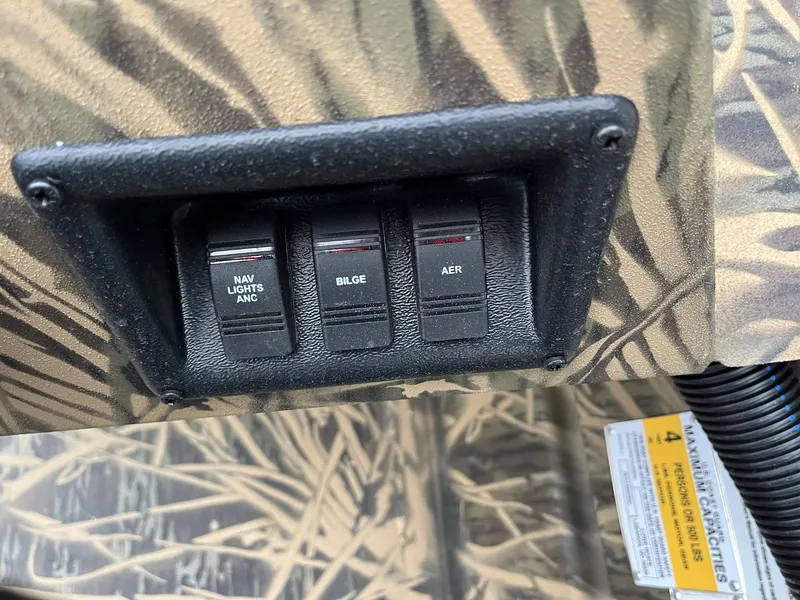 Slide: The Image of Control panel of 2024 Lowe Roughneck RX1660 SC boat with switches for navigation lights, bilge, and aerator. - 14