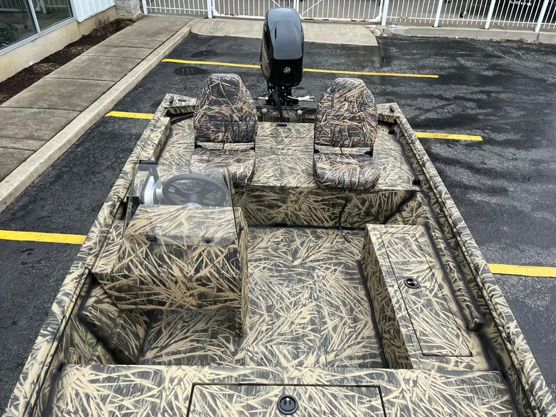 Slide: The Image of 2024 Lowe Roughneck RX1660 SC camo boat with dual seats and outboard motor. - 7