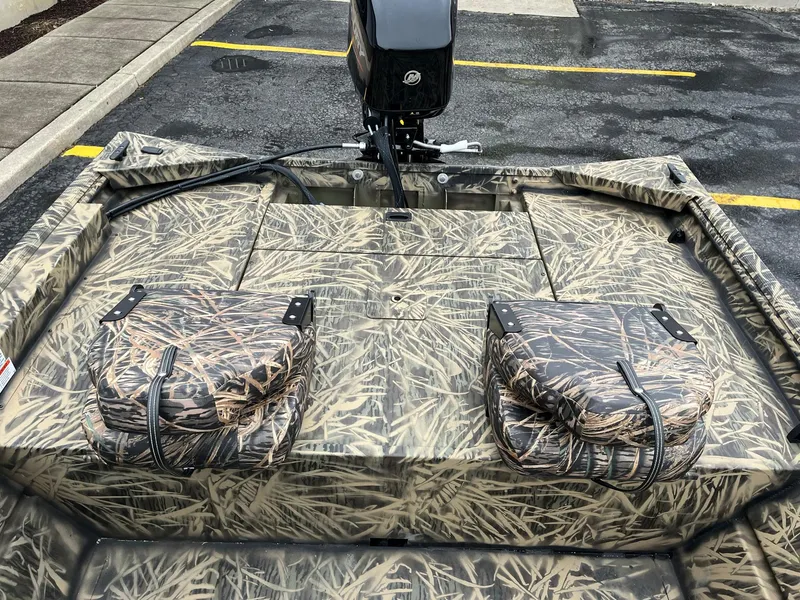 Slide: The Image of 2024 Lowe Roughneck RX1660 SC camo boat with outboard motor in parking lot. - 8