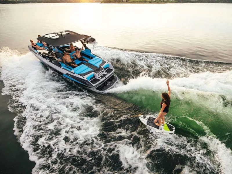 The Image of 2024 ATX Surf Boats 22 Type-S with people wake surfing on a lake. - 1