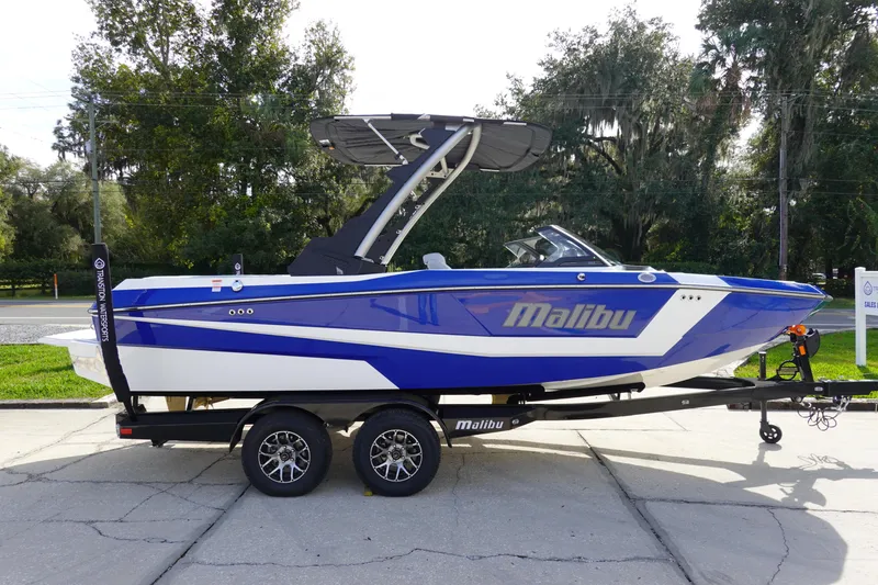Slide: The Image of 2024 Malibu 21 LX-R boat in blue and white on a trailer. - 1