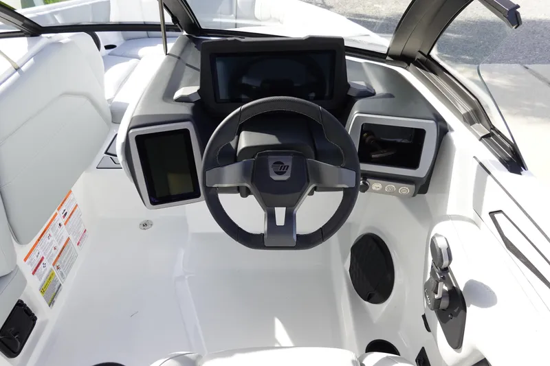 Slide: The Image of 2024 Malibu 21 LX-R boat dashboard with steering wheel and digital displays. - 15