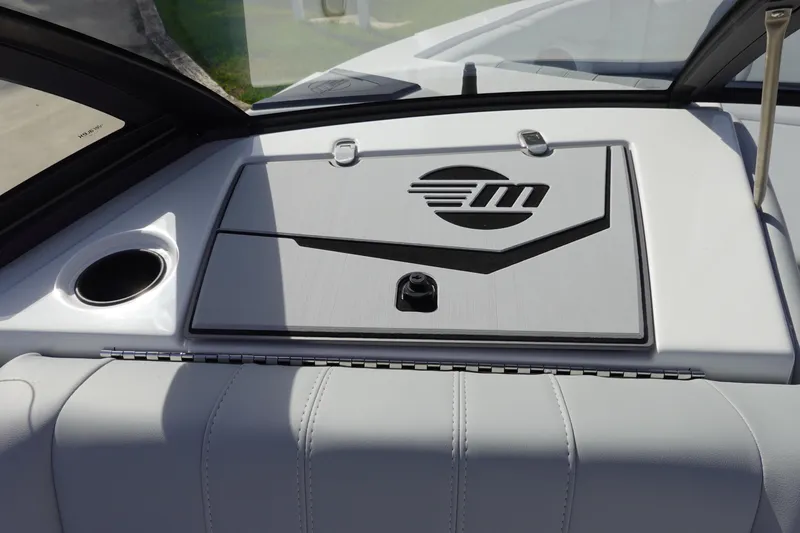 Slide: The Image of 2024 Malibu 21 LX-R boat interior dashboard with logo and cup holder. - 19