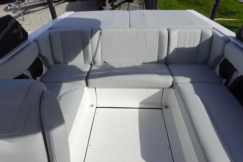 Slide: The Image of 2024 Malibu 21 LX-R boat interior with spacious, cushioned seating in light gray upholstery. - 21
