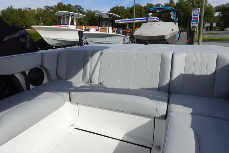 Slide: The Image of Interior seating of 2024 Malibu 21 LX-R boat with other boats in the background. - 22