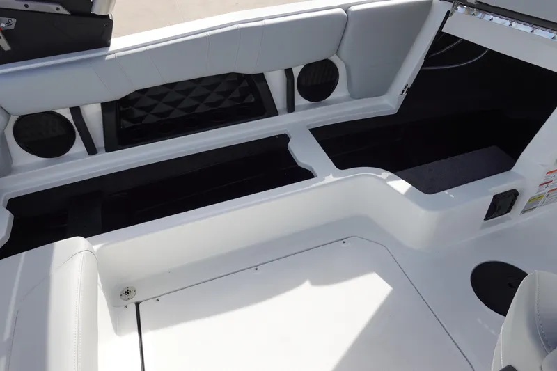 Slide: The Image of 2024 Malibu 21 LX-R boat interior with open storage compartments. - 28