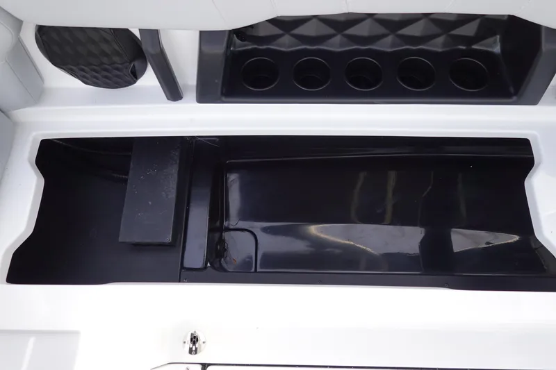 Slide: The Image of 2024 Malibu 21 LX-R boat storage compartment and cup holders. - 29