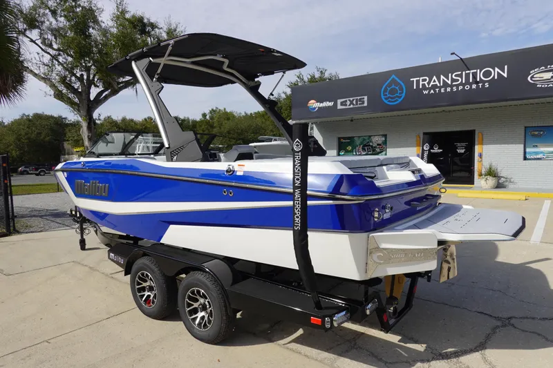 Slide: The Image of 2024 Malibu 21 LX-R boat in blue and white, parked on a trailer at Transition Watersports. - 4