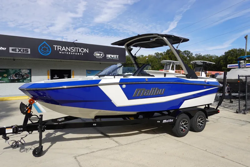 Slide: The Image of 2024 Malibu 21 LX-R boat in blue and white on a trailer at Transition Watersports. - 5