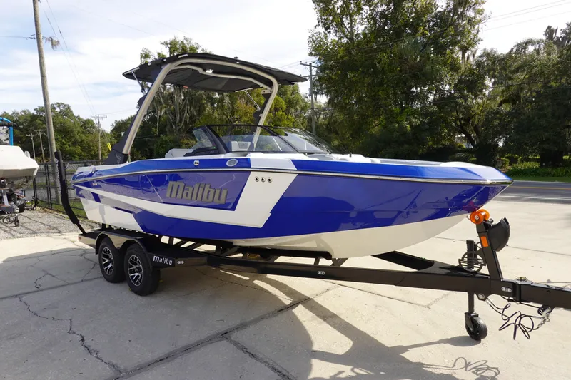Slide: The Image of 2024 Malibu 21 LX-R boat in blue and white on a trailer. - 6